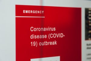 A red emergency sign with 'Coronavirus disease outbreak' written on it.