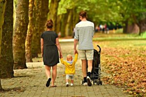 Parents walking their son in the park.