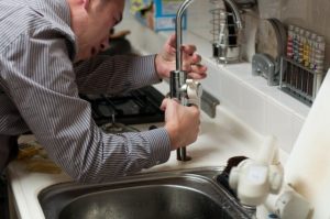 A plumber fixing a kitchen tap